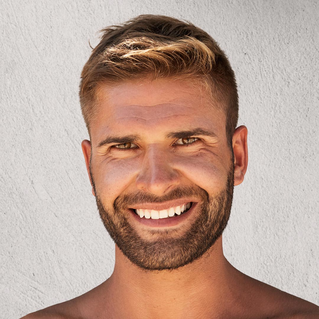 Jeune homme barbu souriant avec une jolie peau